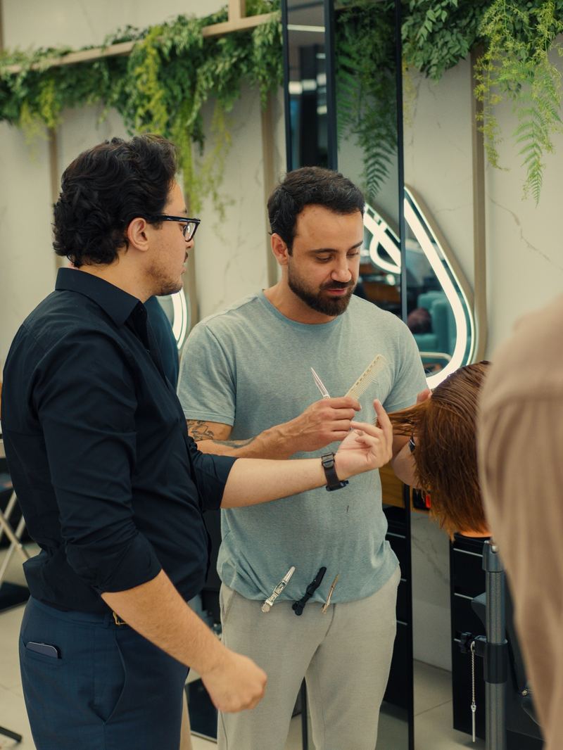 Pedro orientando barbeiros durante uma demonstração de corte