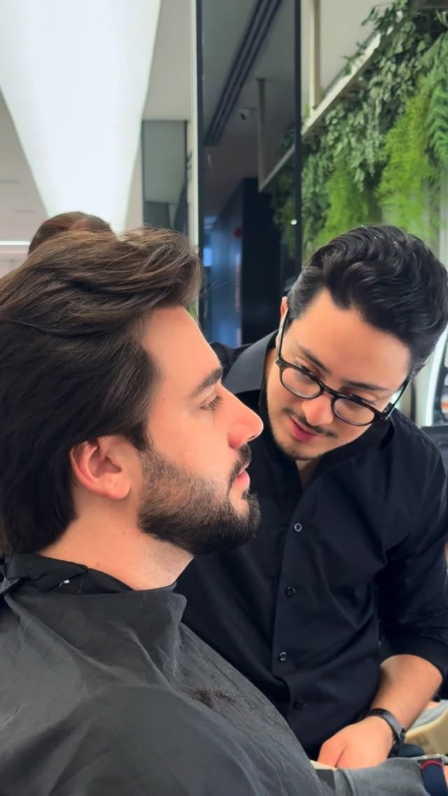Pedro observando de perto o cabelo de um cliente